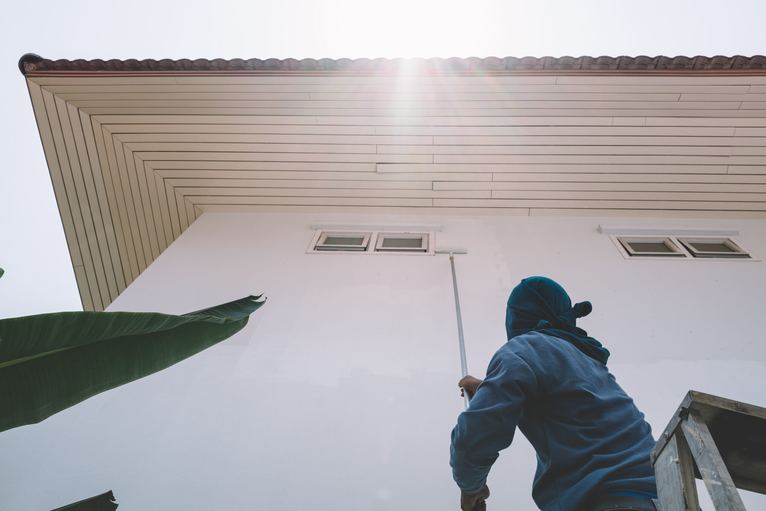 Man painting white wall house faded film look